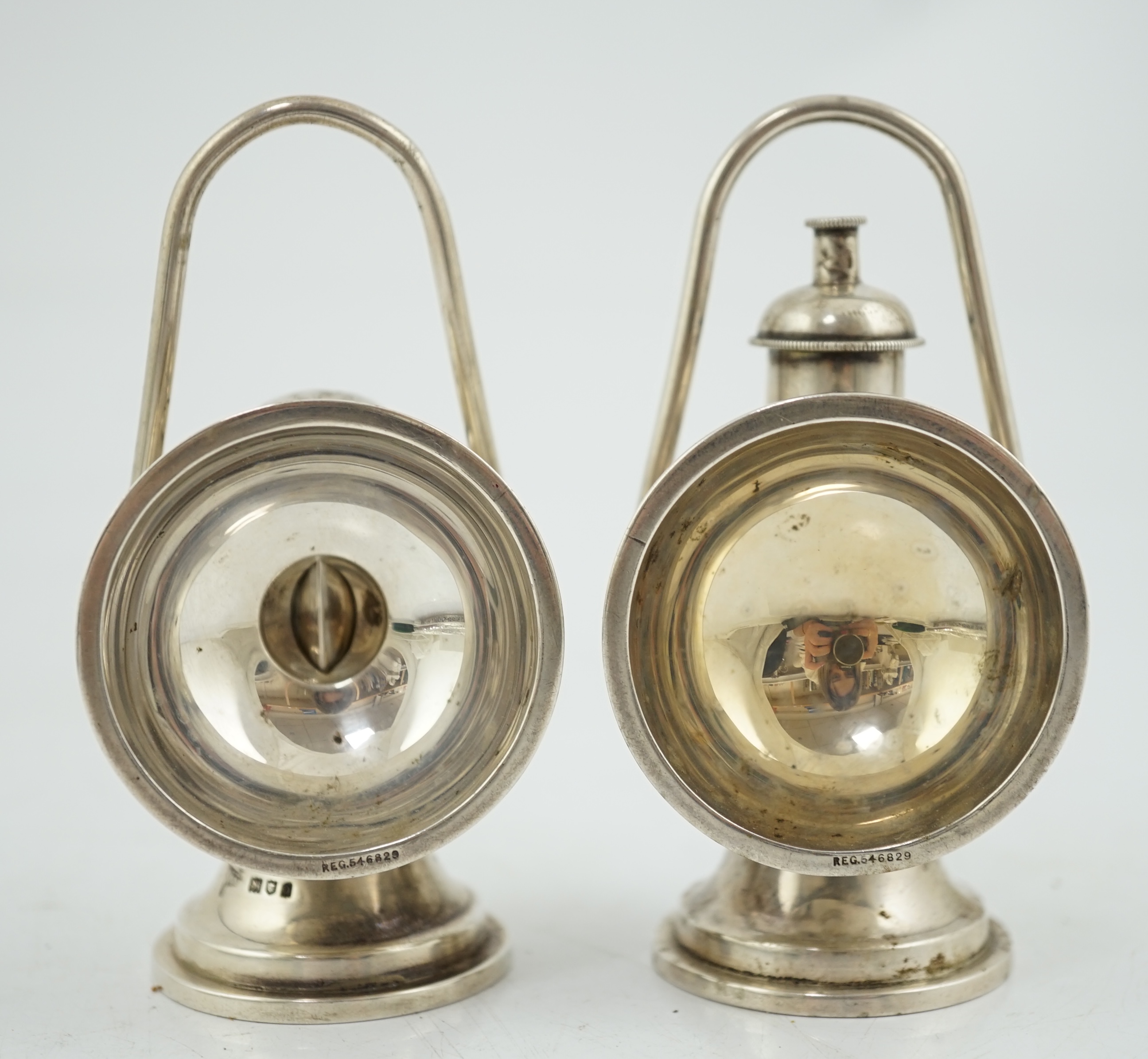 An Edwardian novelty cigar cutter and perpetual lighter, modelled as a pair of railway lamps, by Walker & Hall